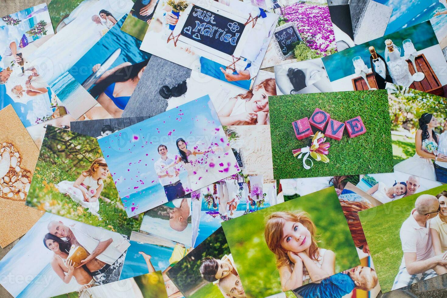 a pile of photos on a table with a couple in the middle