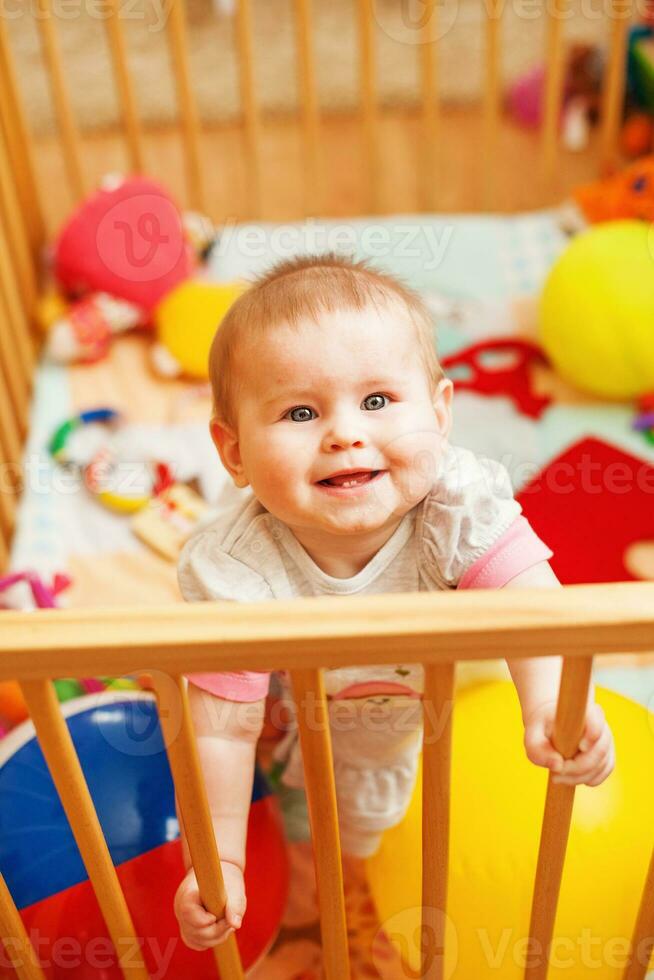 a baby in a crib with toys photo