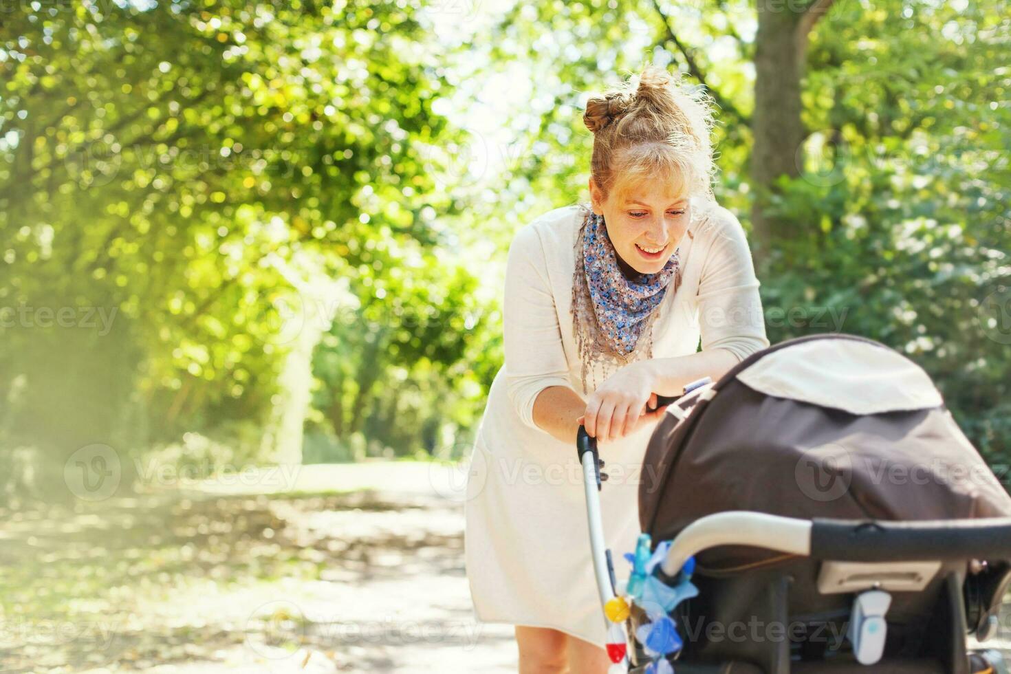 a woman pushing a stroller with a baby in it photo