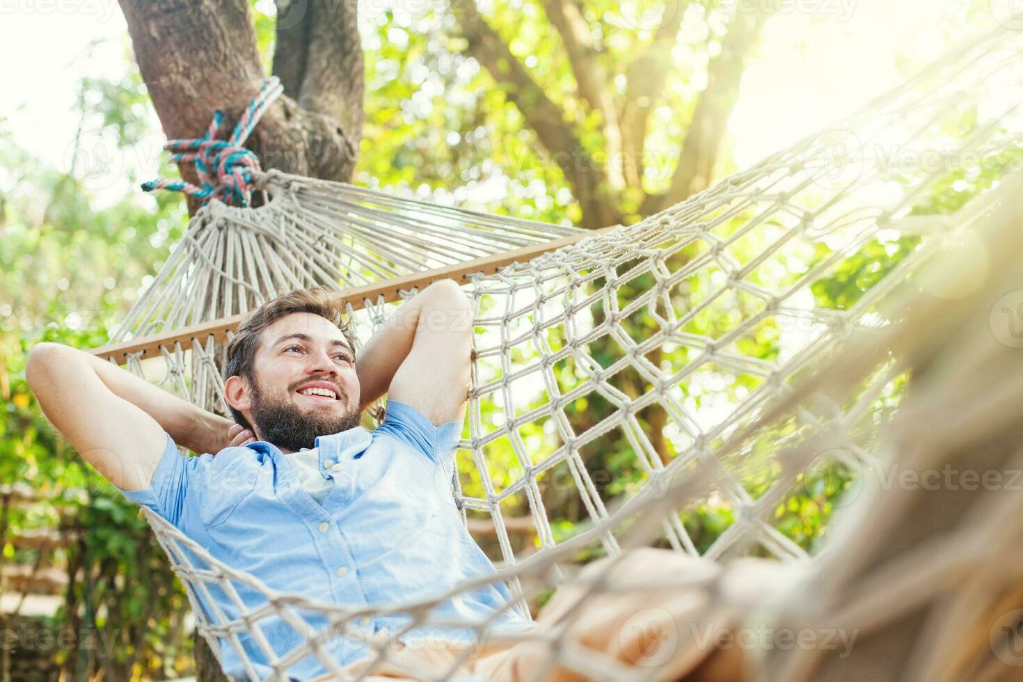 a man is relaxing in a hammock photo