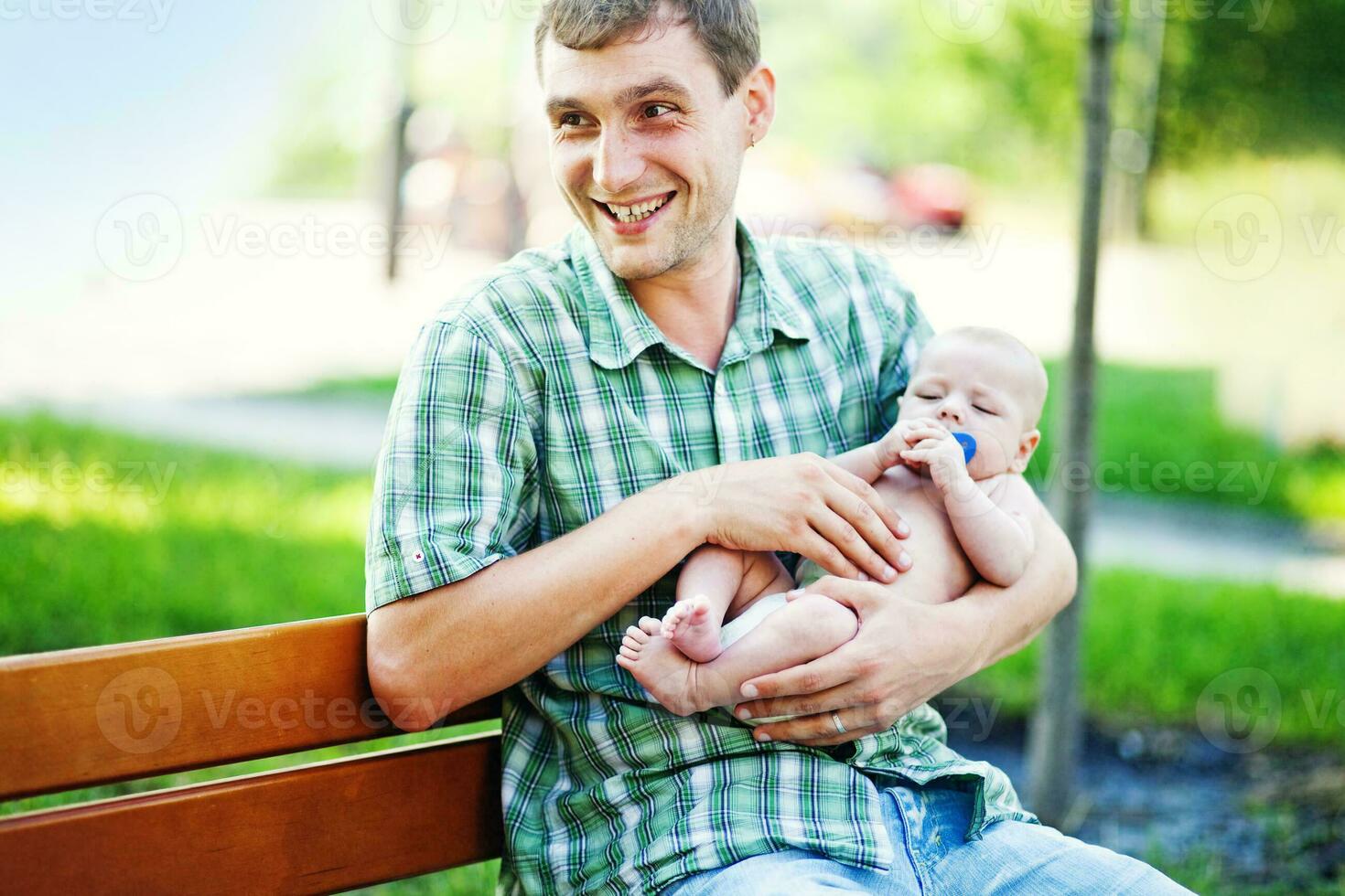 a man sitting on a bench holding a baby photo