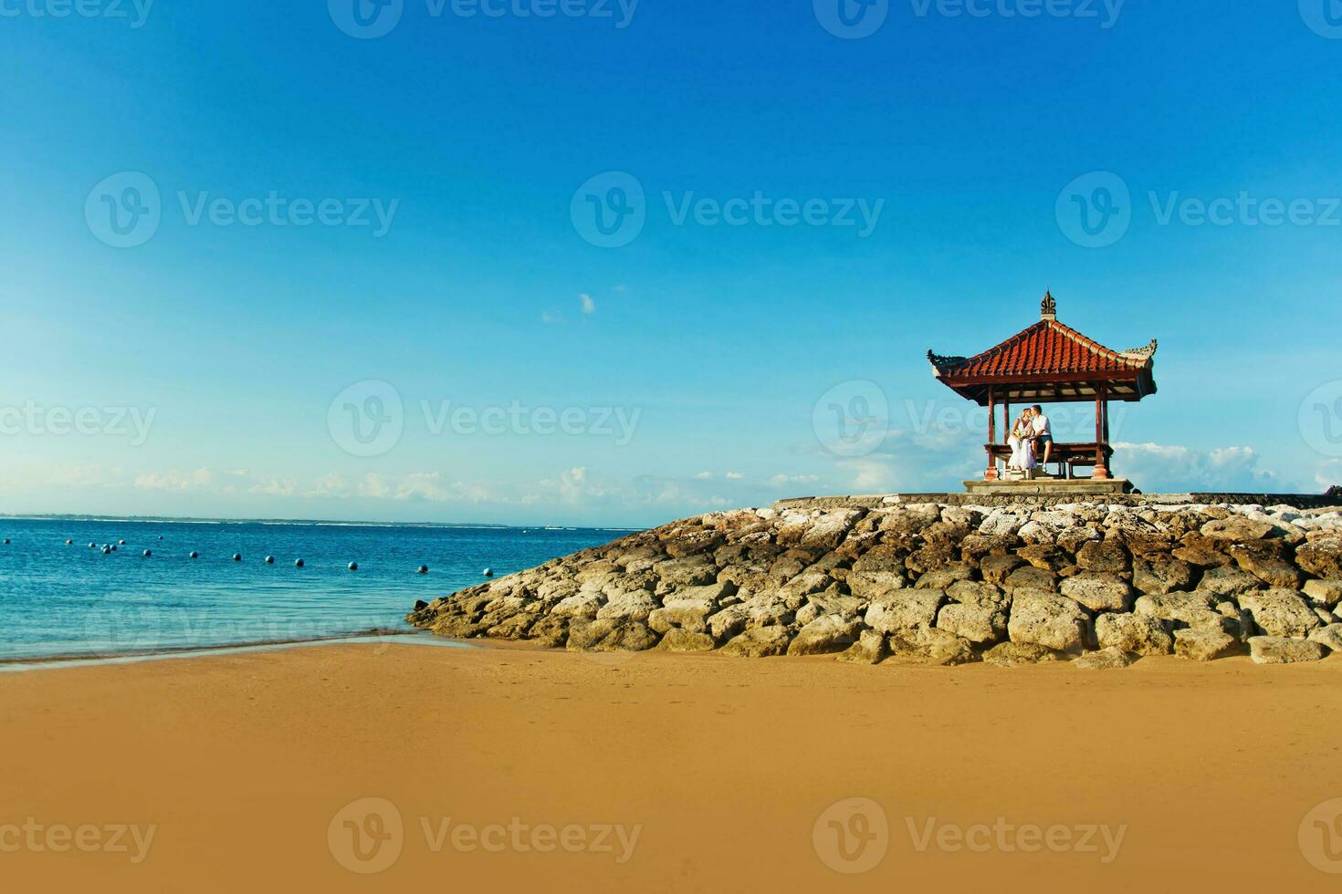 un pequeño pagoda se sienta en el playa siguiente a el Oceano foto