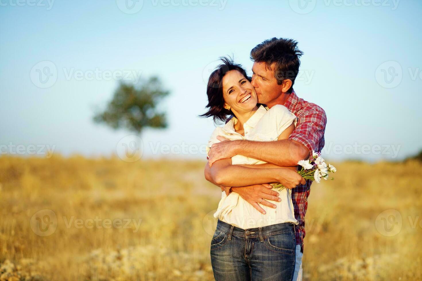 a man and woman hugging in a field photo