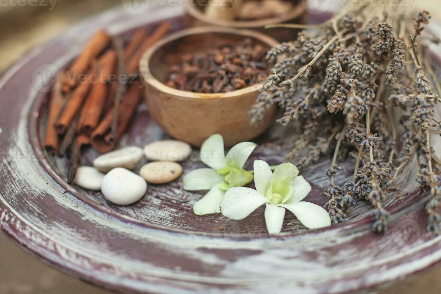 a bowl of herbs and spices on a wooden table photo