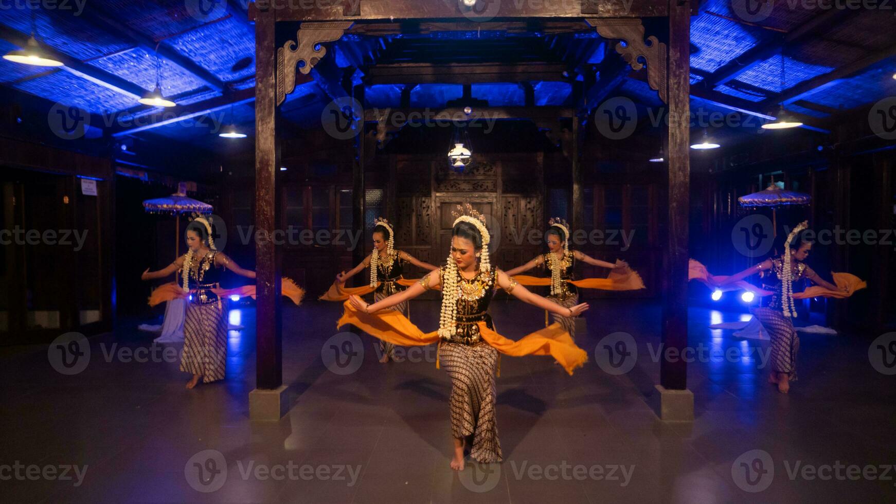 a group of Javanese dancers with their faces full of makeup and jasmine on their heads dance photo