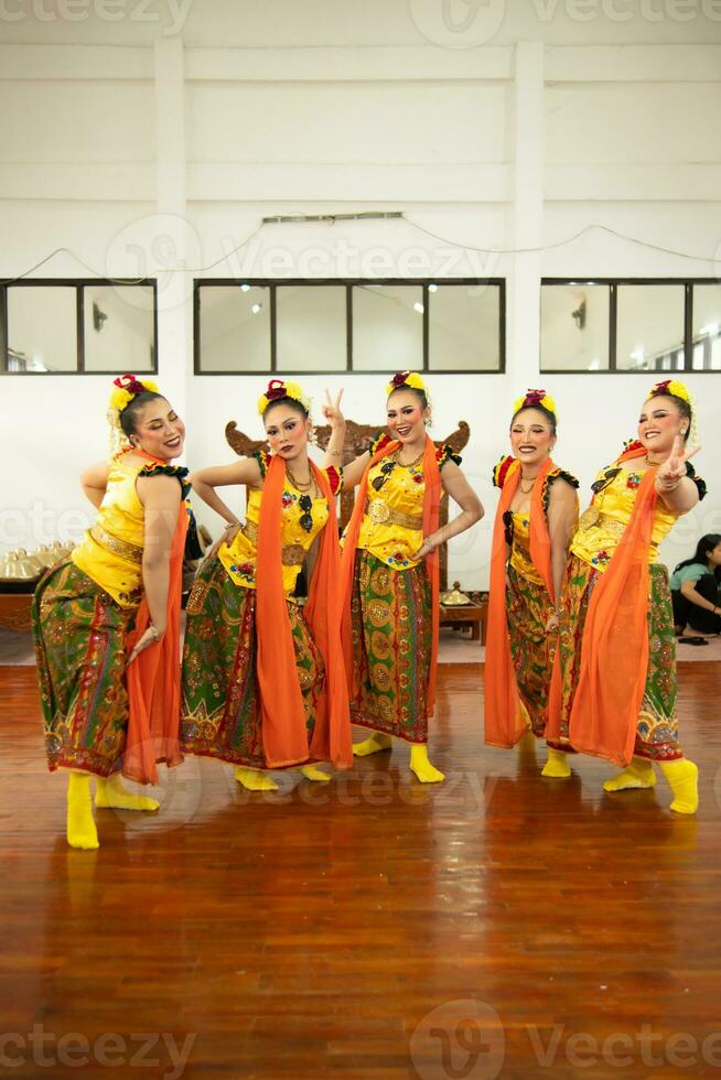 a group of traditional Javanese dancers having fun with their friends on stage after the performance ended photo