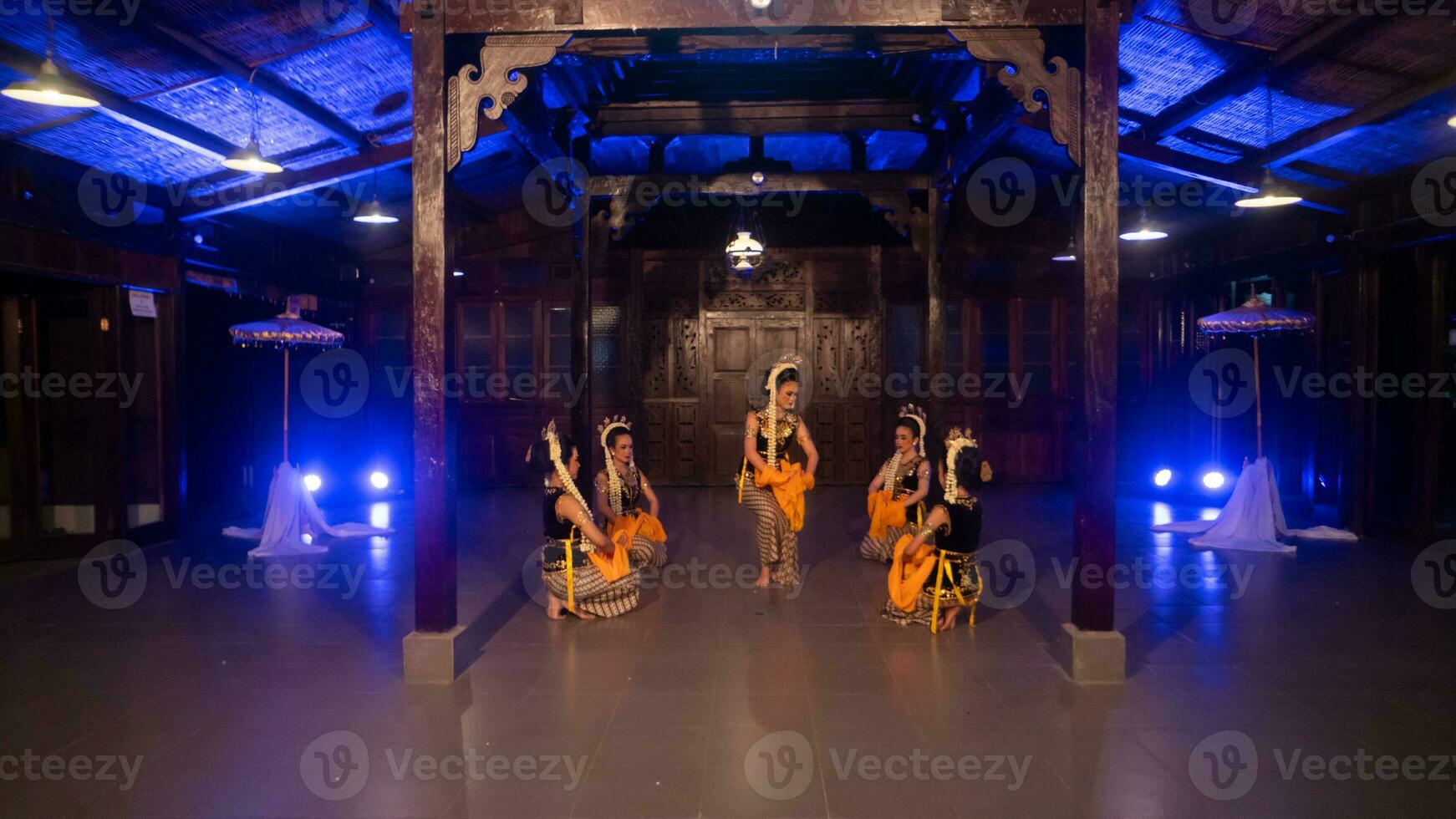 a group of Javanese dancers with their faces full of makeup and jasmine on their heads dance photo