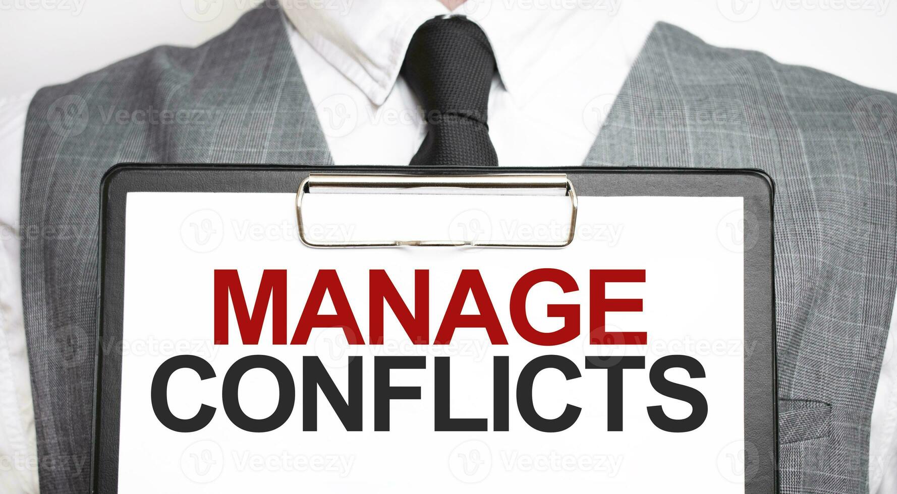 Businessman holding sheet of paper with a message MANAGE CONFLICTS photo