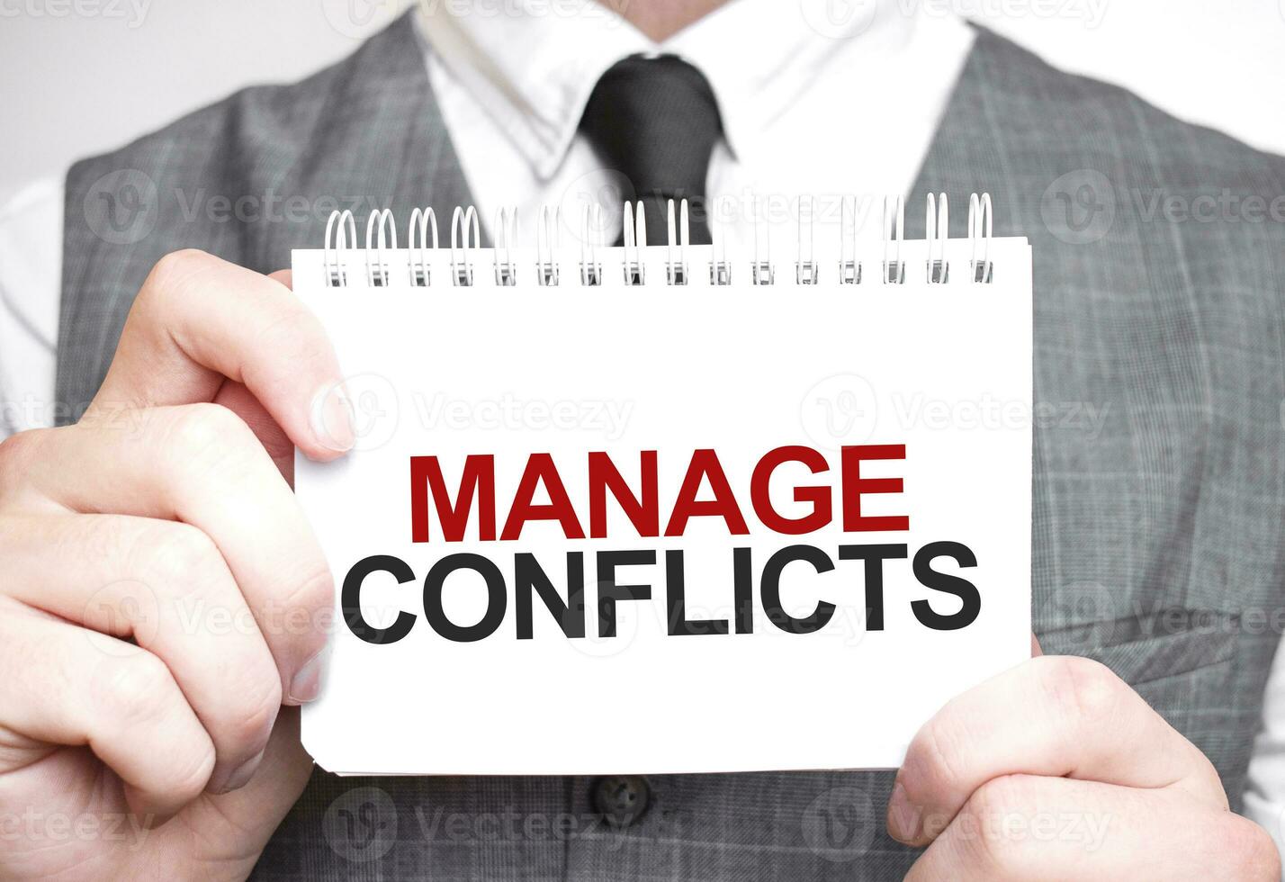 Businessman with notebook with text MANAGE CONFLICTS photo