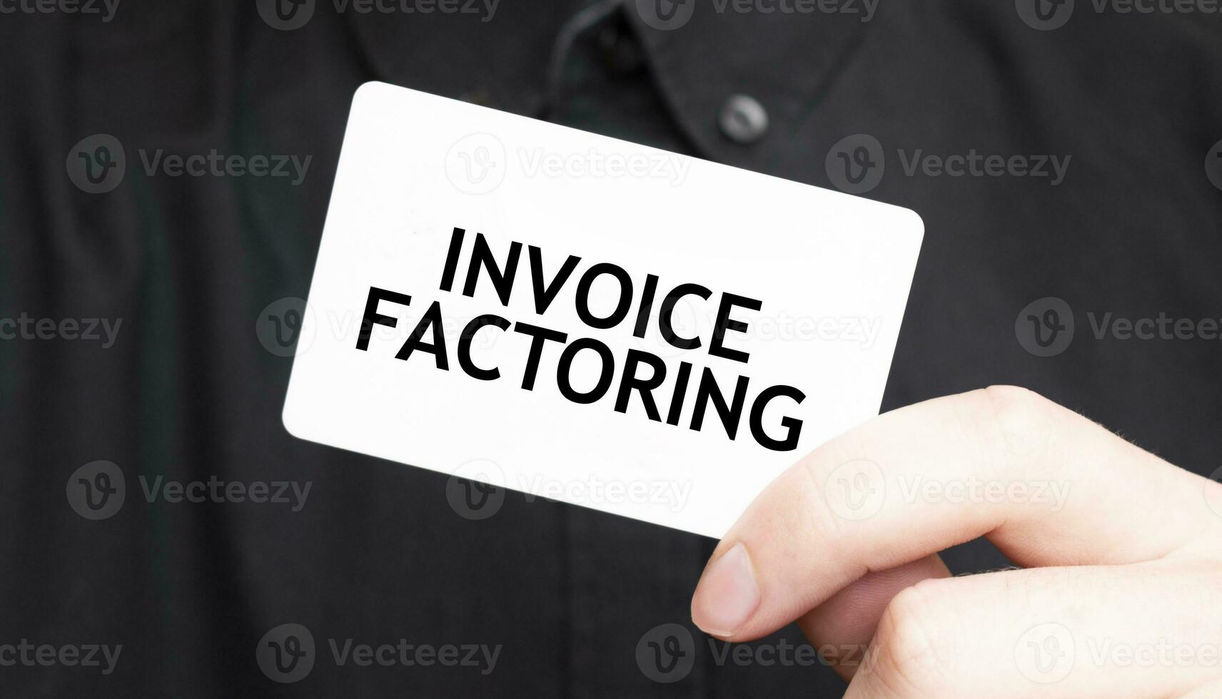 Businessman holding a card with text INVOICE FACTORING, business concept photo