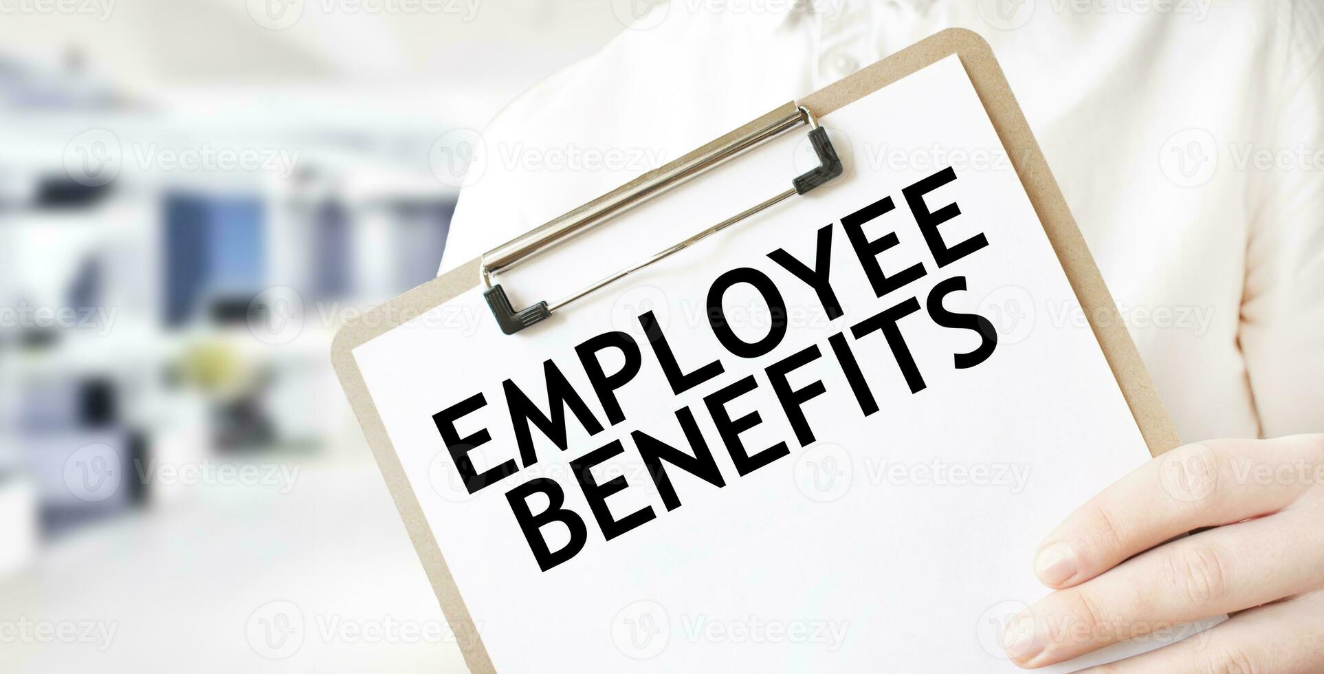 Text EMPLOYEE BENEFITS on white paper plate in businessman hands in office. Business concept photo