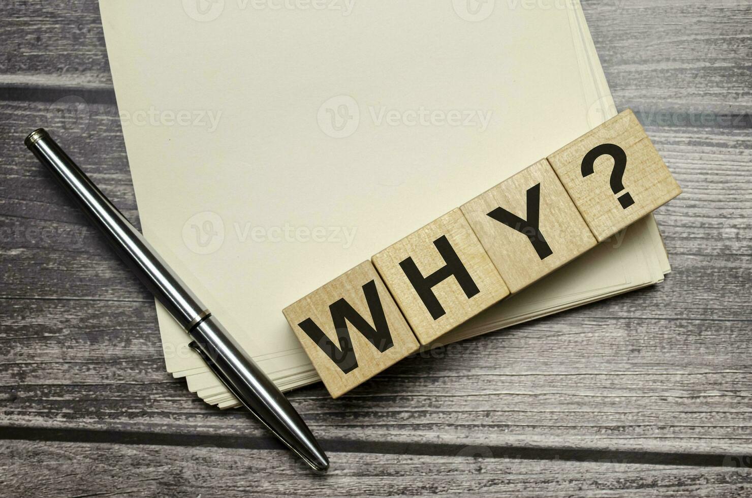 why Word Written In Wooden Cubes on notebook with pen photo