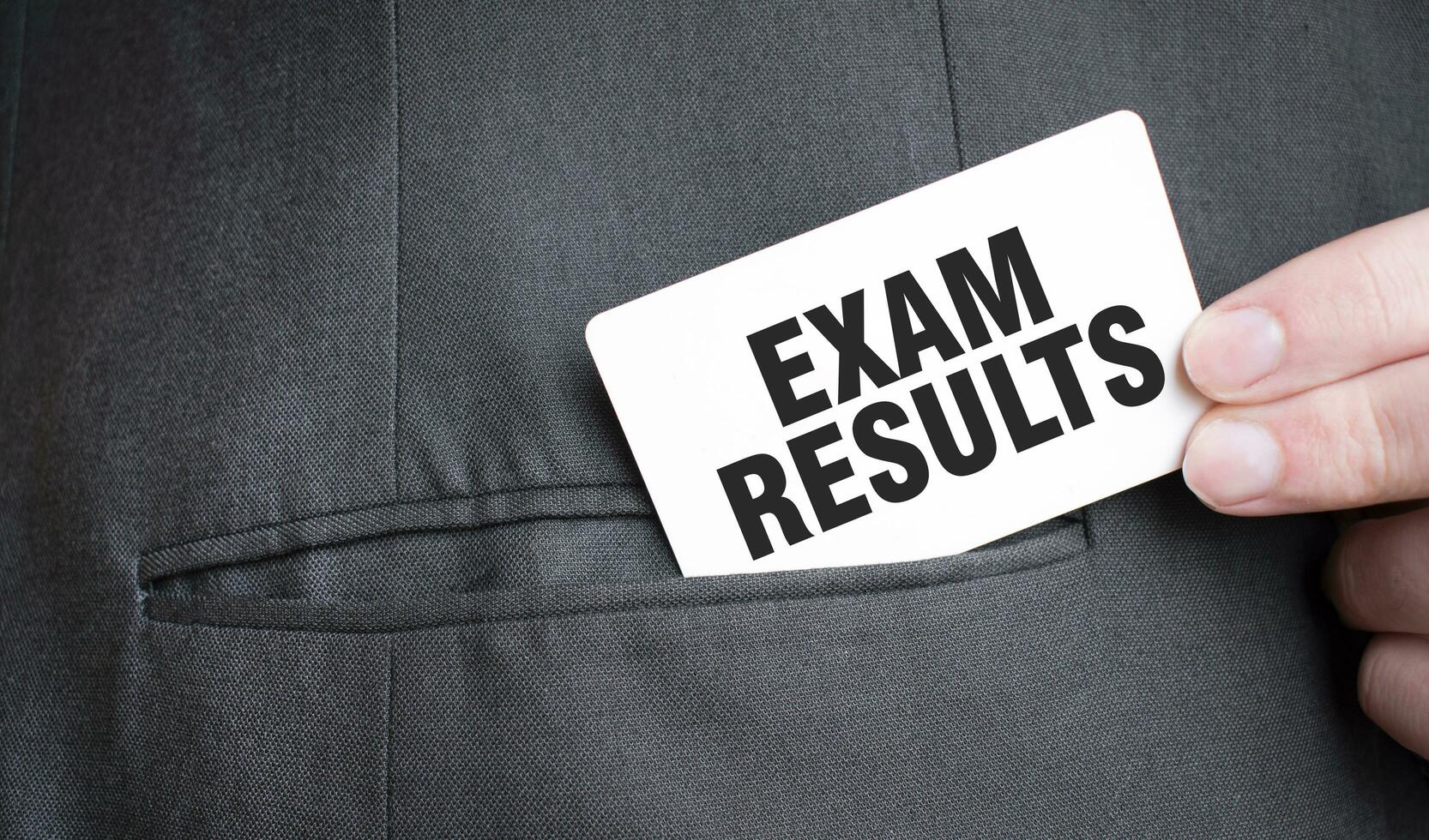 Card with EXAM RESULTS text in pocket of businessman suit. Investment and decisions business concept. photo