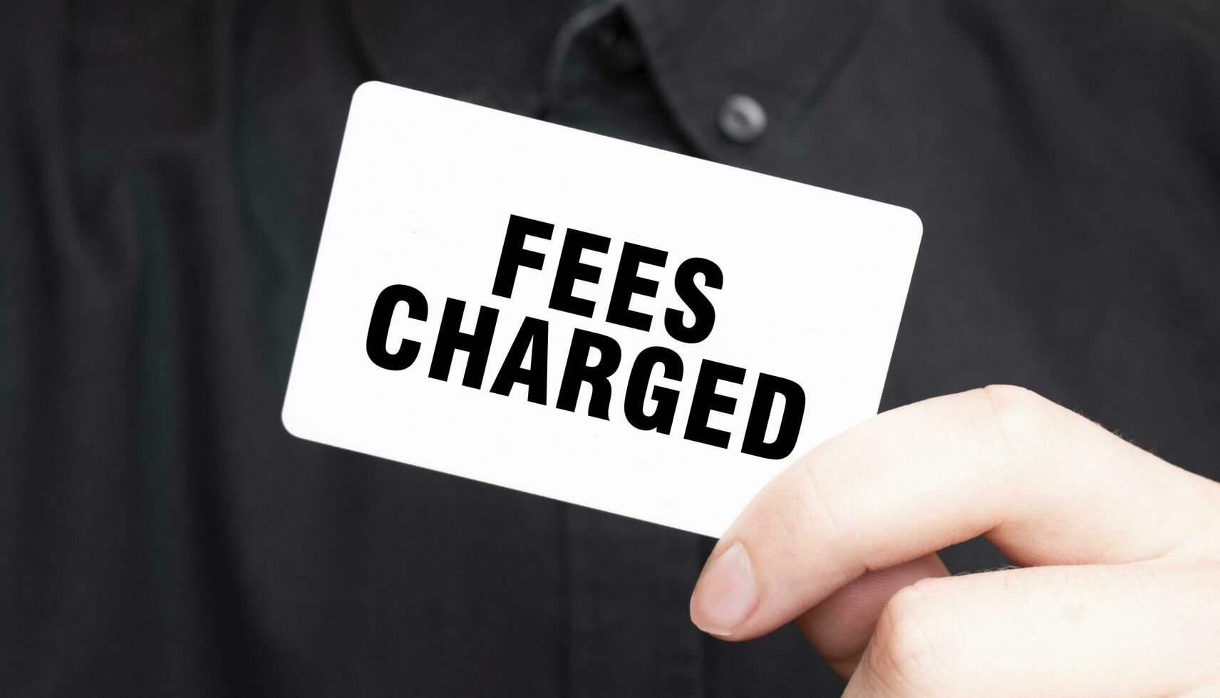Businessman holding a card with text FEES CHARGED, business concept photo