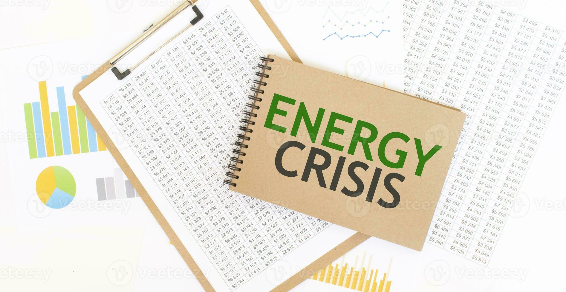 Text ENERGY CRISIS on brown paper notepad on the table with diagram. Business concept photo