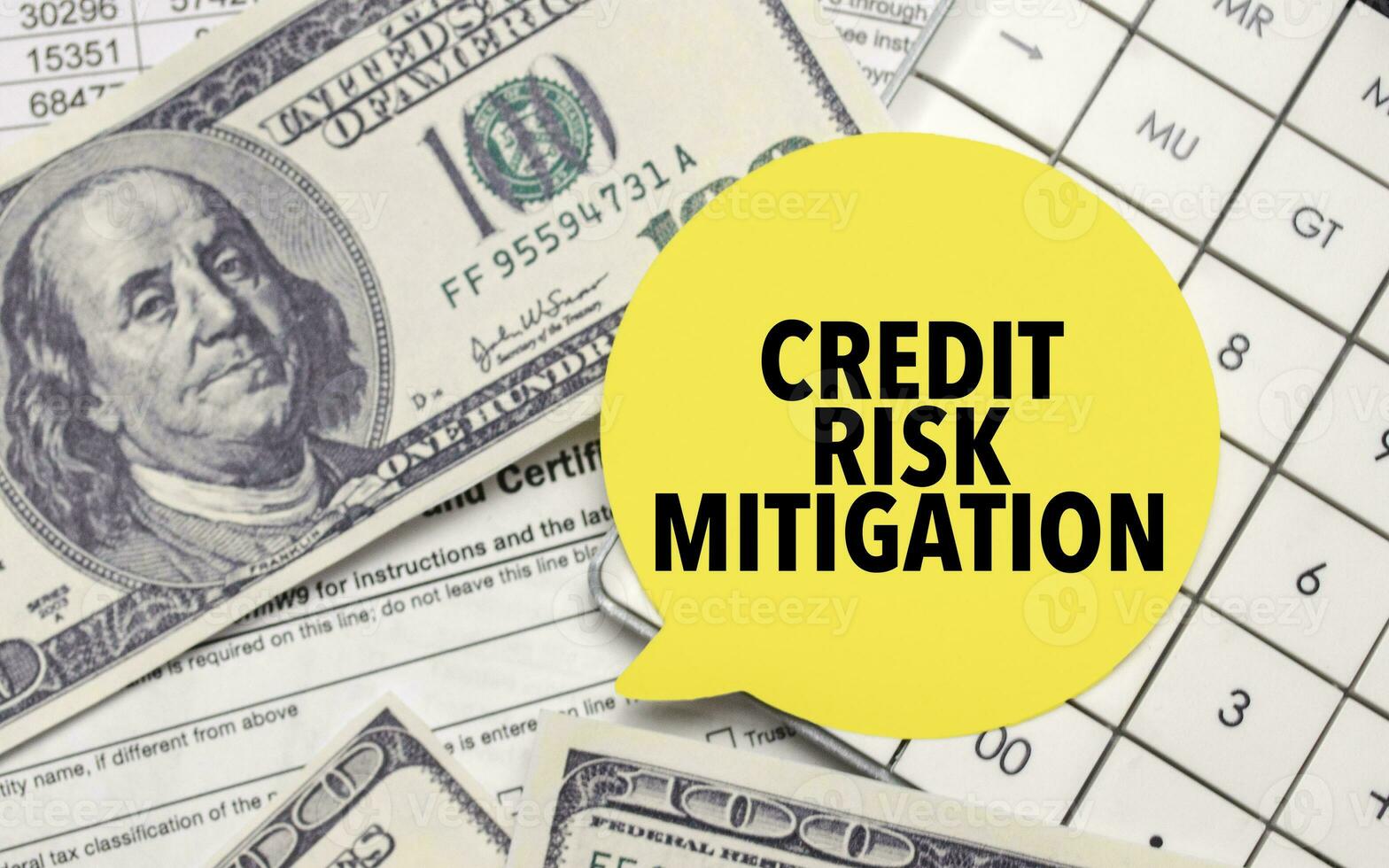 CREDIT RISK MITIGATION words on yellow sticker with dollars and charts photo