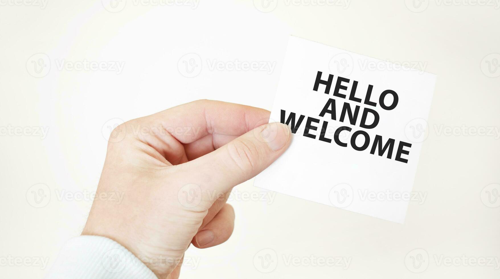 Businessman holding a card with text HELLO AND WELCOME business concept photo