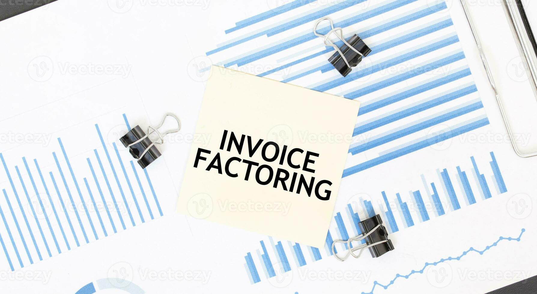 Yellow sticky notes with text INVOICE FACTORING on the white office desk. Business concept. photo