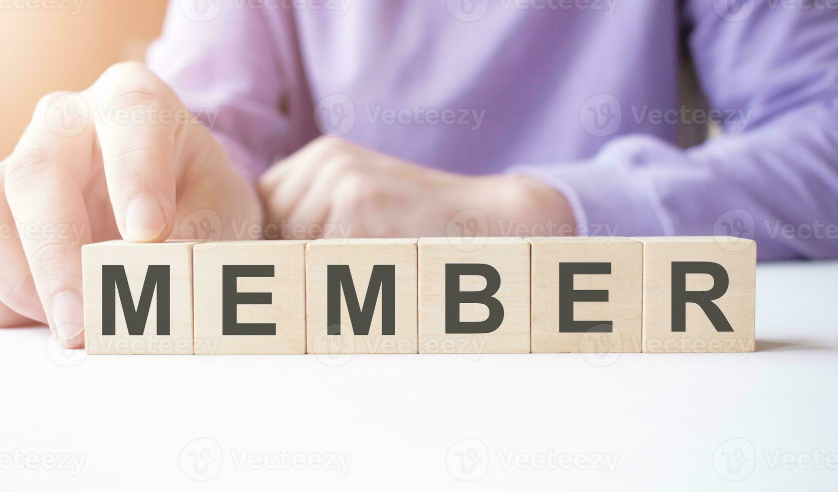 Businessman hand holding wooden cube block with MEMBER business word on table background. photo