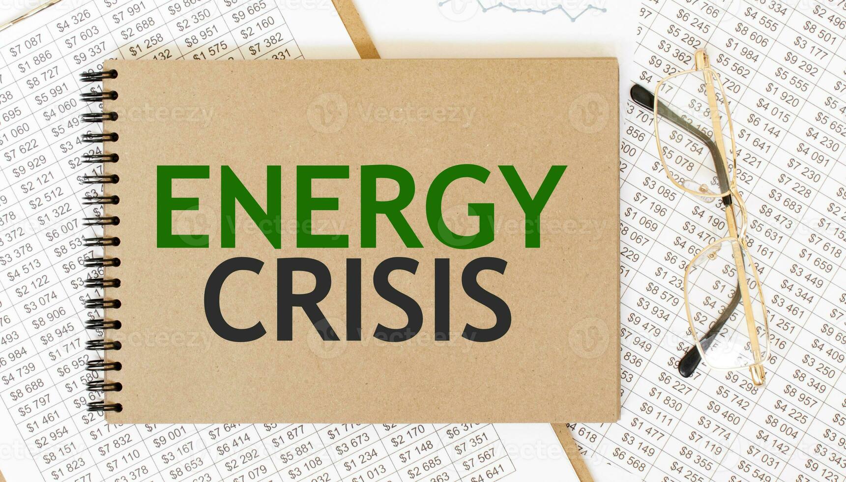 Craft colour notepad with text ENERGY CRISIS. Notepad with eyeglasses and text documents. Business concept photo