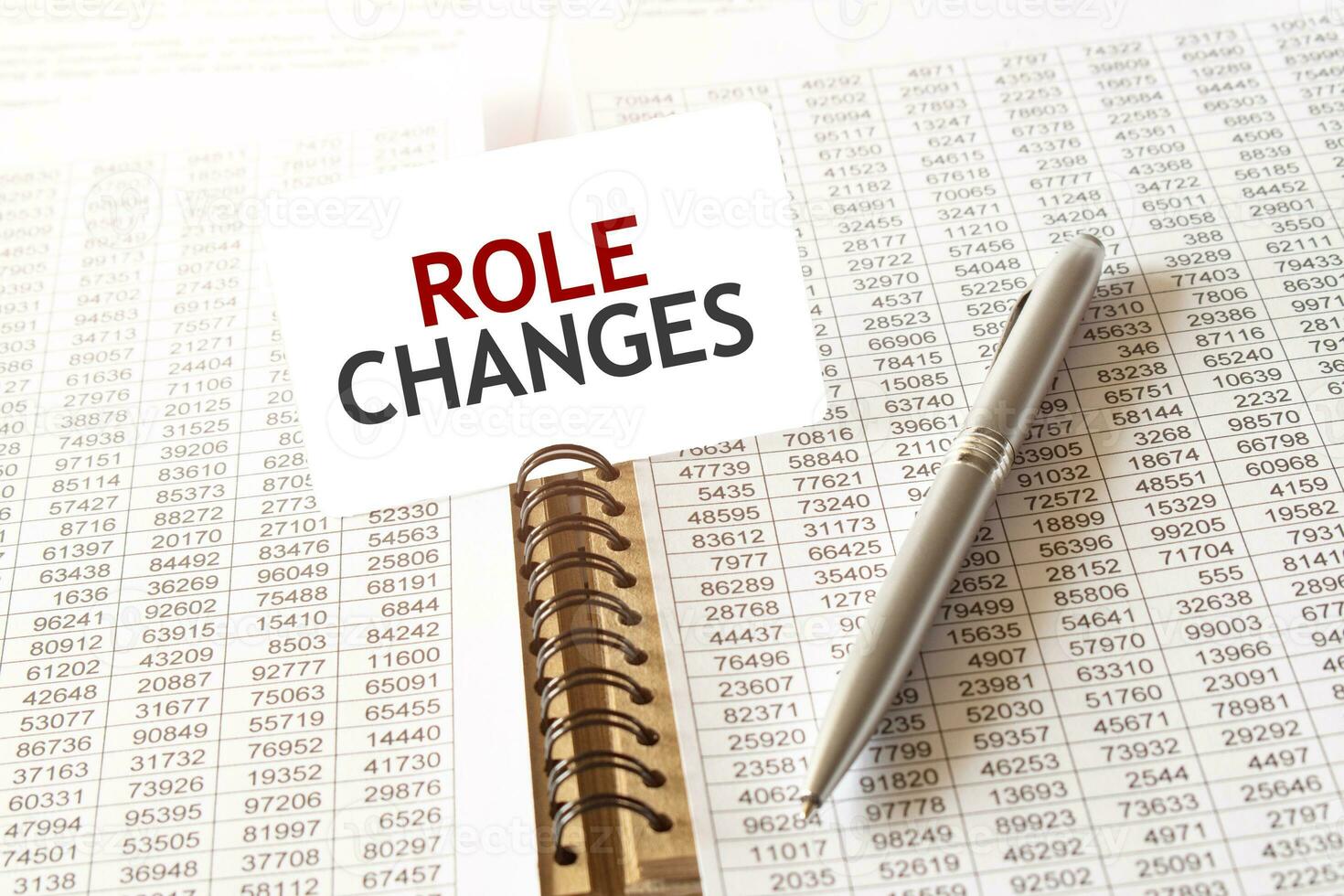Text ROLE CHANGEs on paper card, pen, financial documentation on table photo