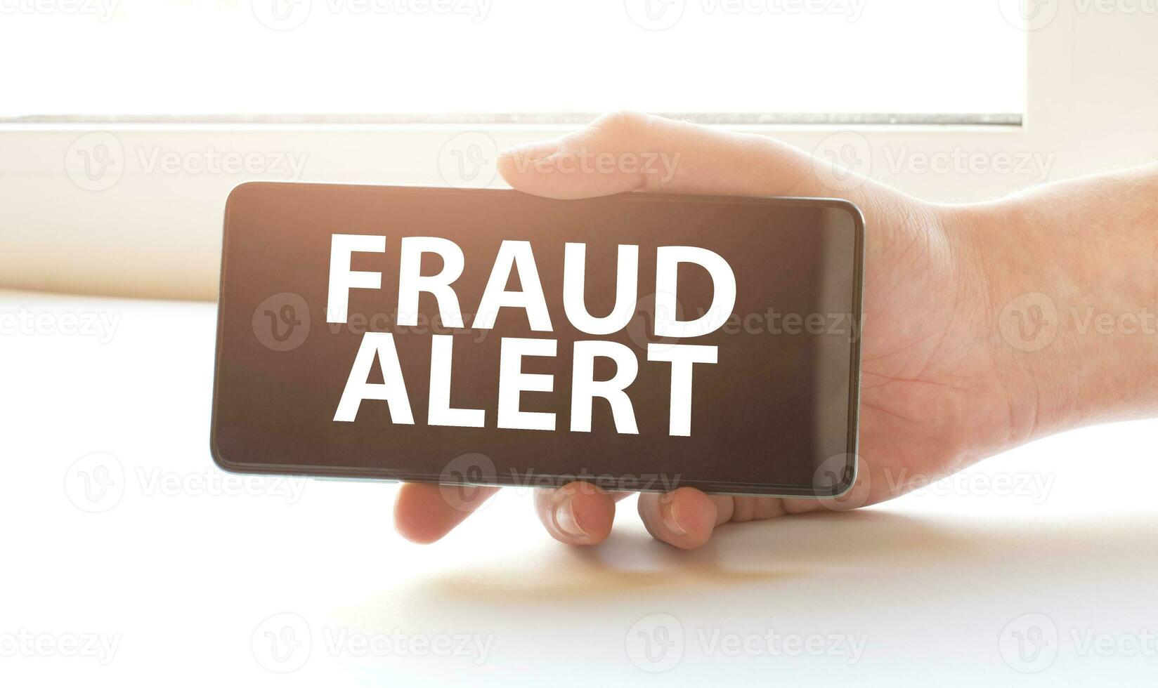 fraud alert on display in hands on white background photo