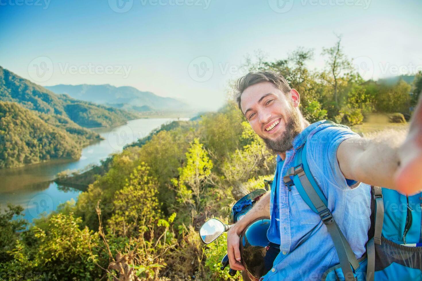 a man with a backpack taking a selfie photo