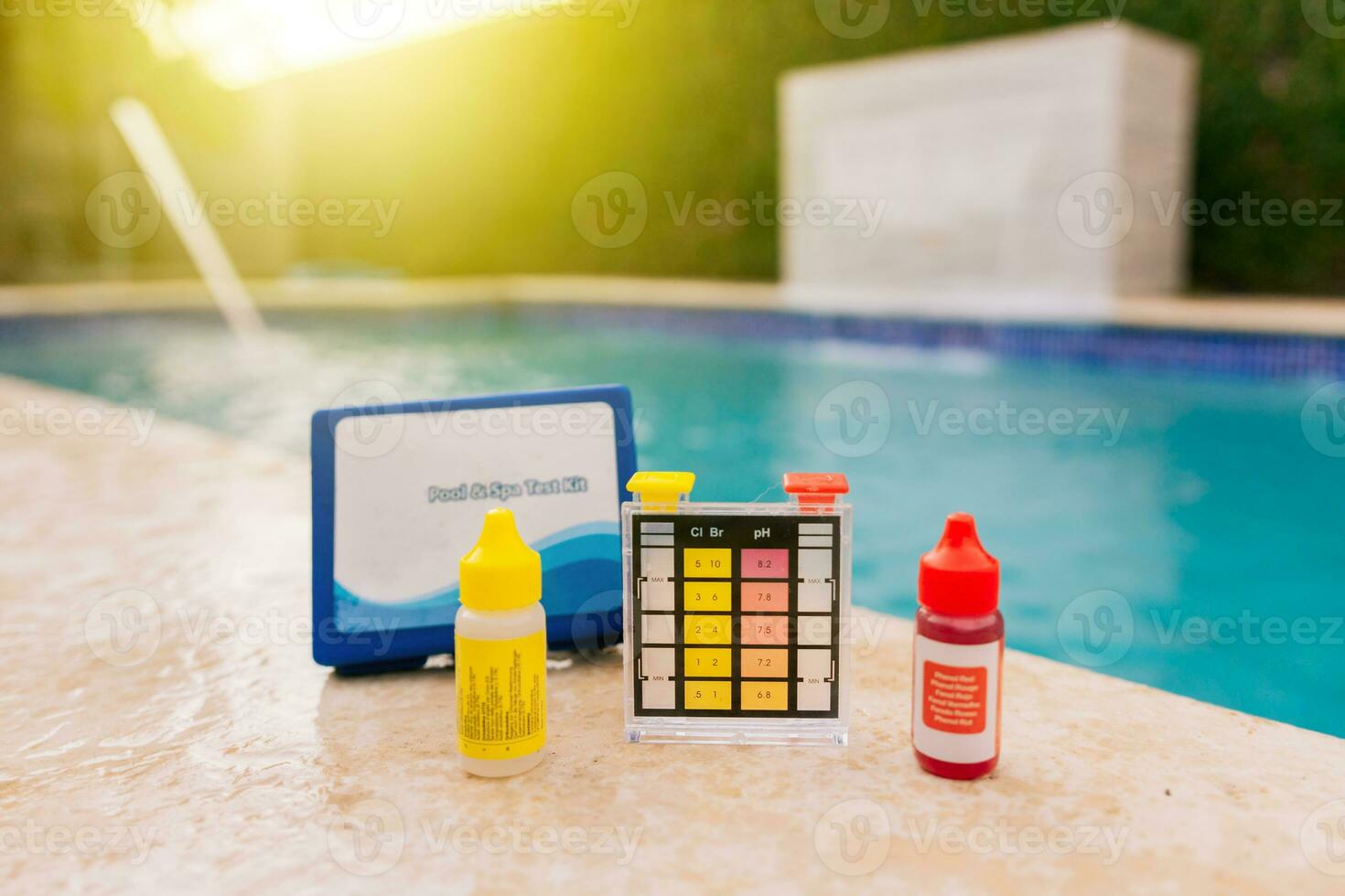 Chlorine test kit on the edge of the pool. PH tester for pool maintenance. Water test kit for swimming pools, Chlorine and ph tester for swimming pools photo