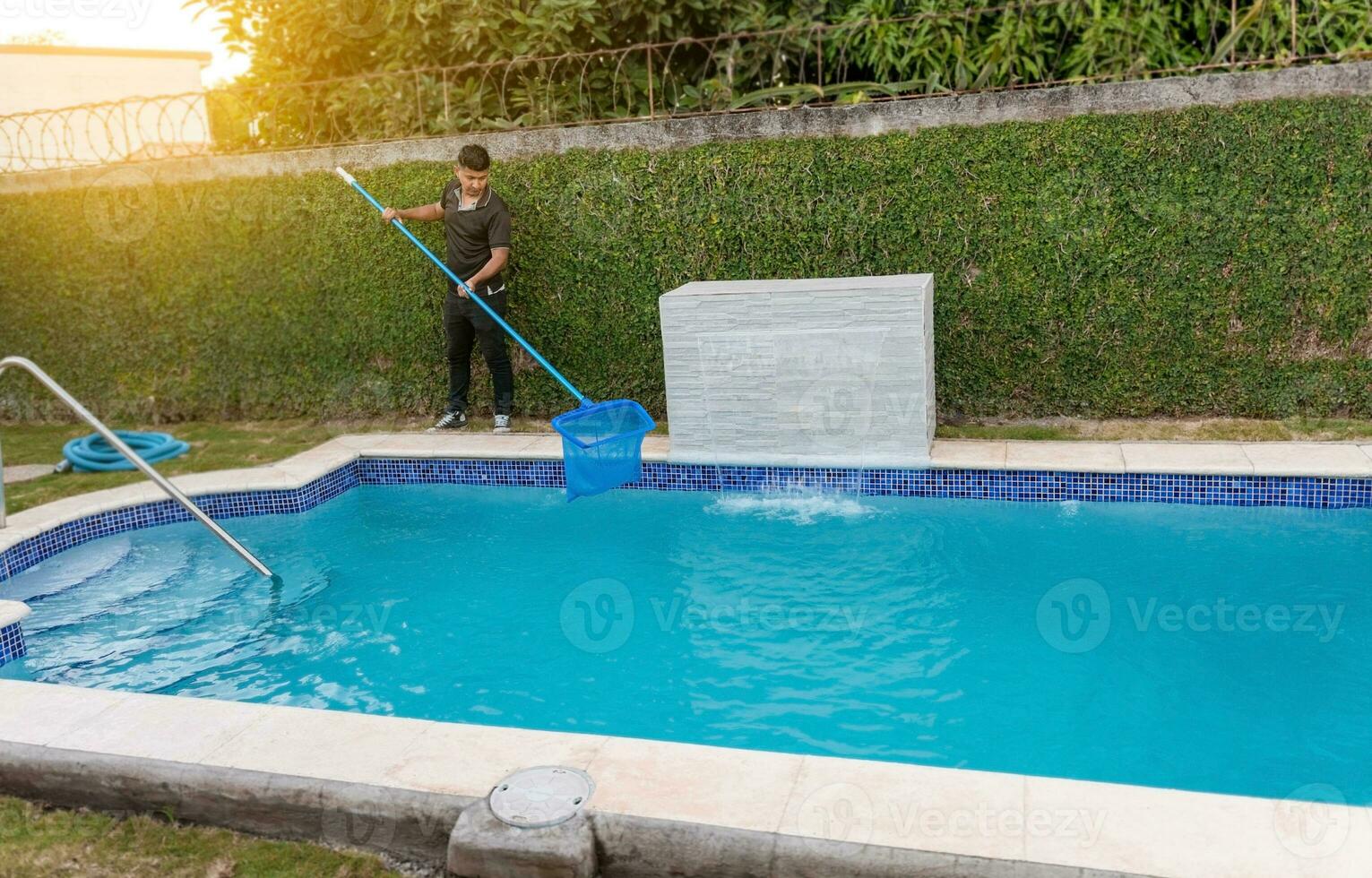 mantenimiento persona limpieza un nadando piscina con desnatadora, trabajador limpieza un nadando piscina con desnatadora. nadando piscina limpieza y mantenimiento concepto foto