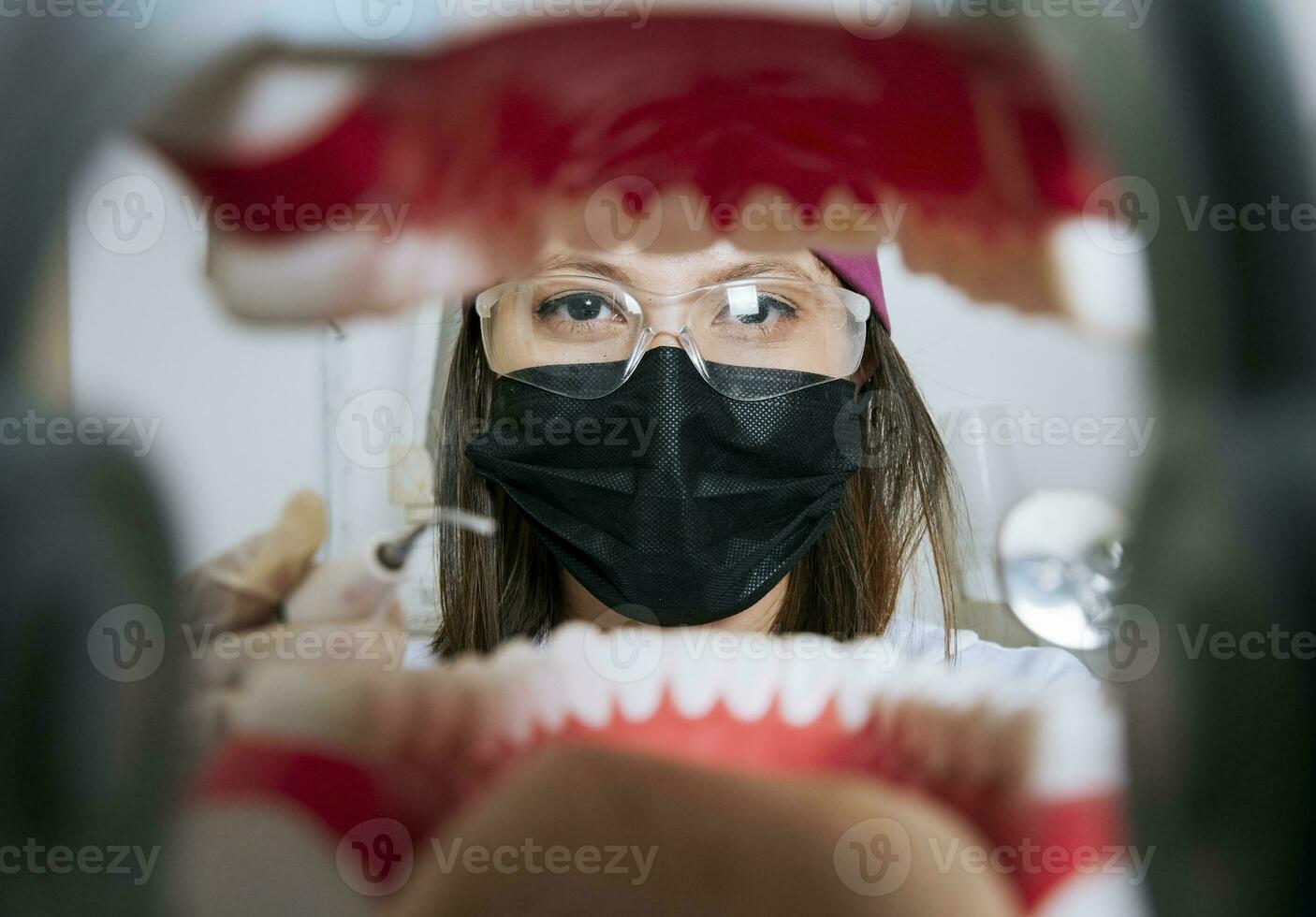 Woman dentist cleaning a mouth inside view, Inside view of a mouth checked by a dentist, a female dentist checking a patient. dentist checking a mouth, a dentist cleaning teeth photo