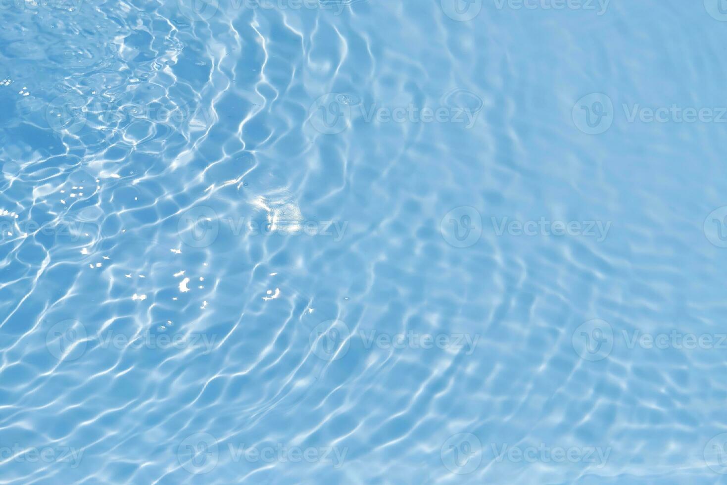 Blue water with ripples on the surface. Defocus blurred transparent blue colored clear calm water surface texture with splashes and bubbles. Water waves with shining pattern texture background. photo