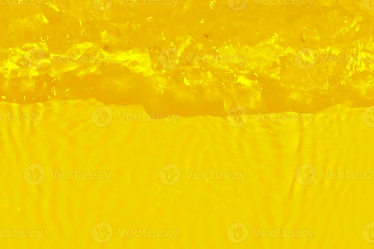 dorado agua con ondas en el superficie. desenfocar borroso transparente oro de colores claro calma agua superficie textura con salpicaduras y burbujas agua olas con brillante modelo textura antecedentes. foto