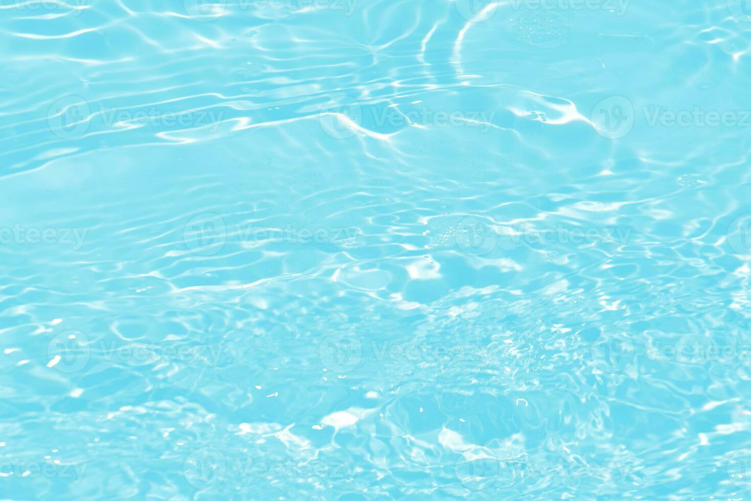 Blue water with ripples on the surface. Defocus blurred transparent blue colored clear calm water surface texture with splashes and bubbles. Water waves with shining pattern texture background. photo
