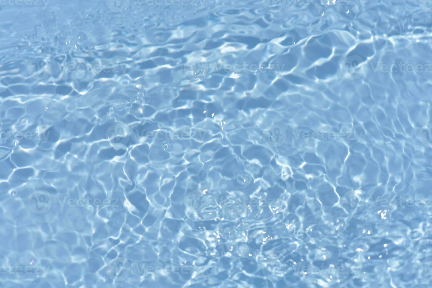 Blue water with ripples on the surface. Defocus blurred transparent blue colored clear calm water surface texture with splashes and bubbles. Water waves with shining pattern texture background. photo