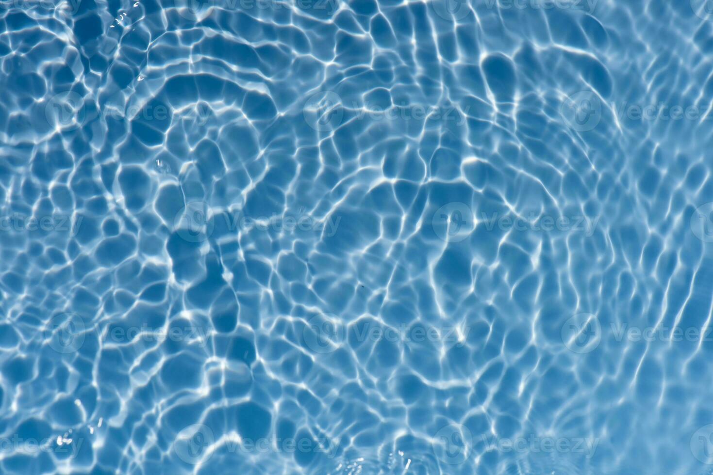 Blue water with ripples on the surface. Defocus blurred transparent blue colored clear calm water surface texture with splashes and bubbles. Water waves with shining pattern texture background. photo