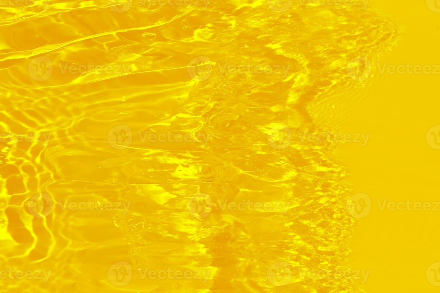 Golden water with ripples on the surface. Defocus blurred transparent gold colored clear calm water surface texture with splashes and bubbles. Water waves with shining pattern texture background. photo