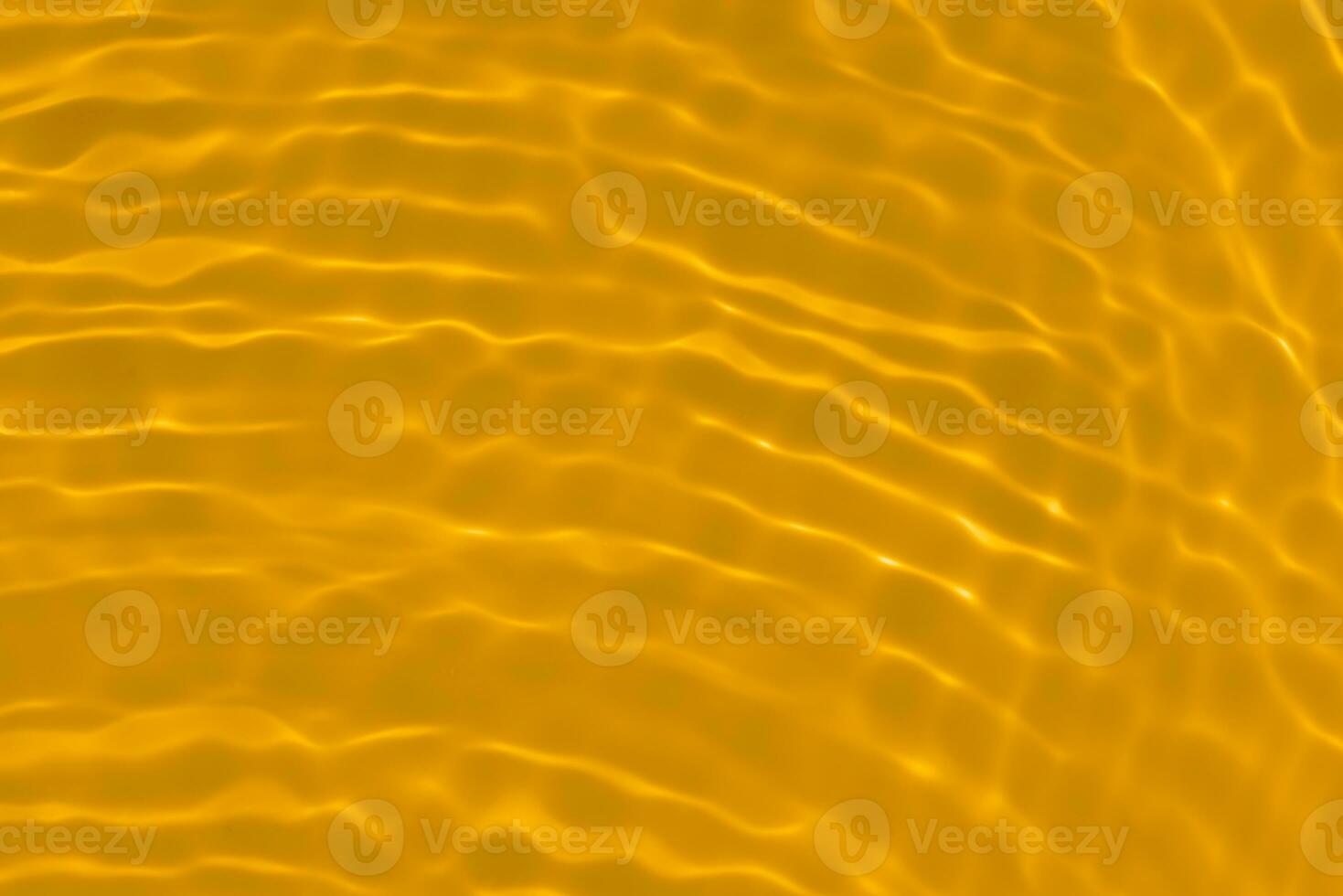 Golden water with ripples on the surface. Defocus blurred transparent gold colored clear calm water surface texture with splashes and bubbles. Water waves with shining pattern texture background. photo