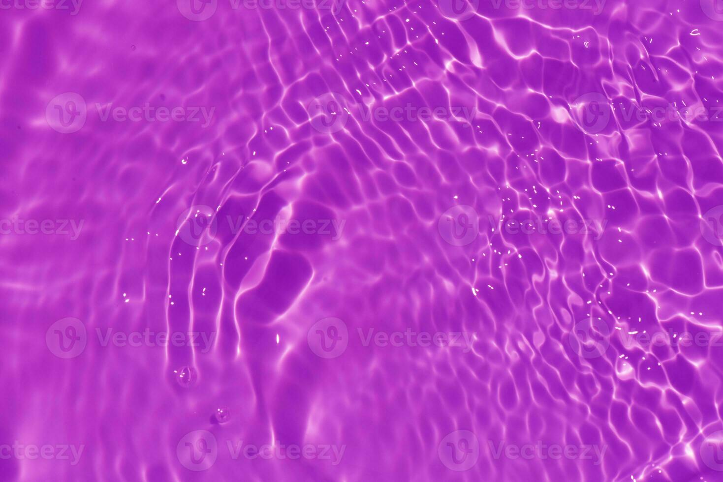 Purple water with ripples on the surface. Defocus blurred transparent pink colored clear calm water surface texture with splashes and bubbles. Water waves with shining pattern texture background. photo