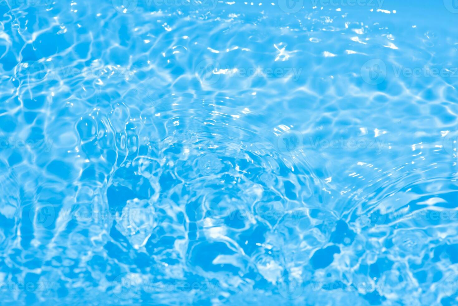 Blue water with ripples on the surface. Defocus blurred transparent blue colored clear calm water surface texture with splashes and bubbles. Water waves with shining pattern texture background. photo