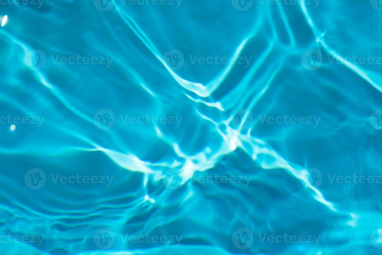 Blue water with ripples on the surface. Defocus blurred transparent blue colored clear calm water surface texture with splashes and bubbles. Water waves with shining pattern texture background. photo