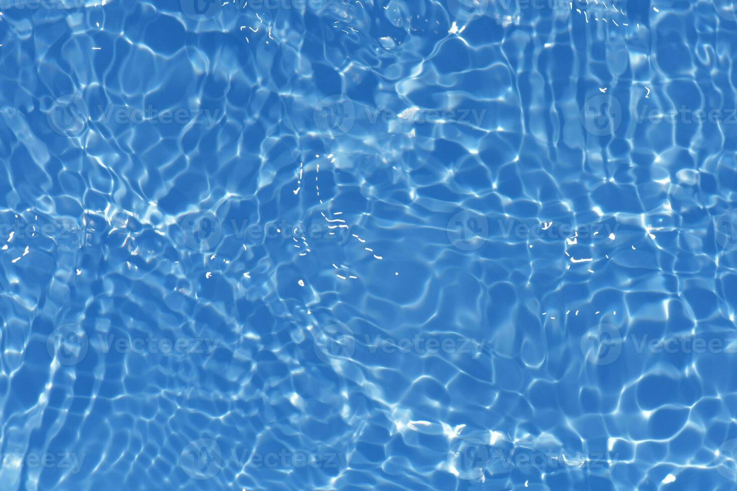 Blue water with ripples on the surface. Defocus blurred transparent blue colored clear calm water surface texture with splashes and bubbles. Water waves with shining pattern texture background. photo