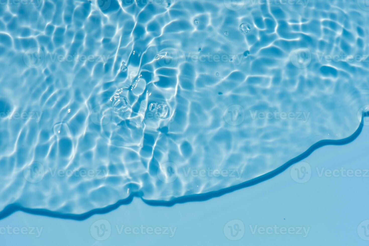 Blue water with ripples on the surface. Defocus blurred transparent blue colored clear calm water surface texture with splashes and bubbles. Water waves with shining pattern texture background. photo