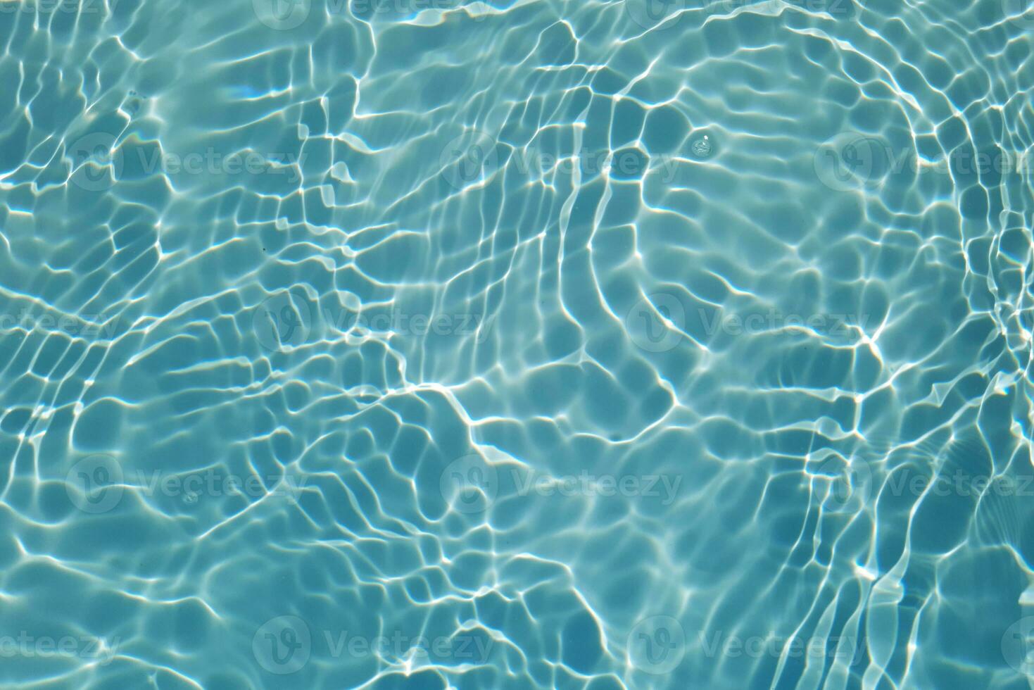 Blue water with ripples on the surface. Defocus blurred transparent blue colored clear calm water surface texture with splashes and bubbles. Water waves with shining pattern texture background. photo