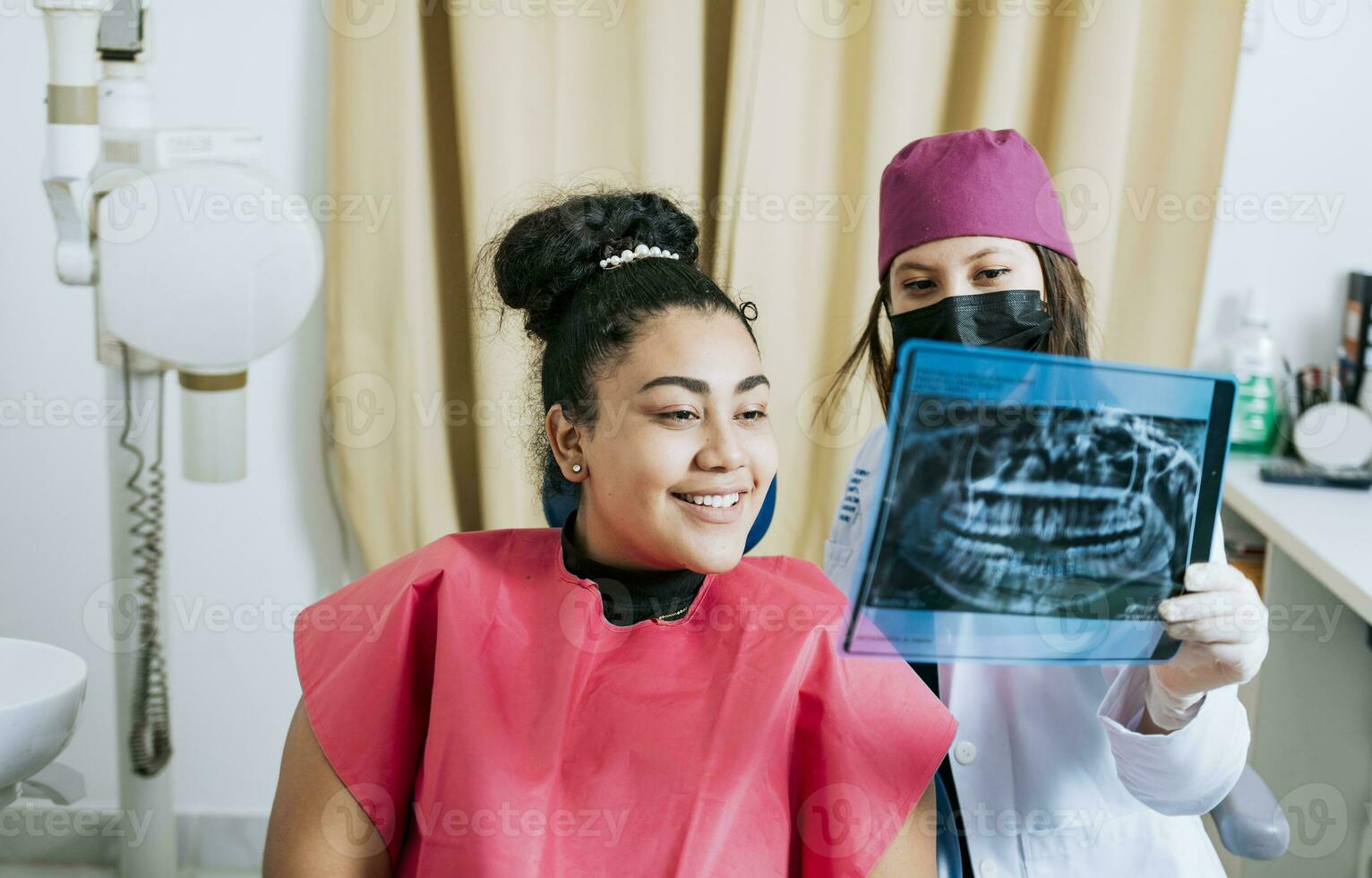 Dentist with patient reviewing the x-ray. Patient looking at x-ray with dentist, Concept of dentist showing x-ray examination to female patient, Dentist showing patient x-ray photo