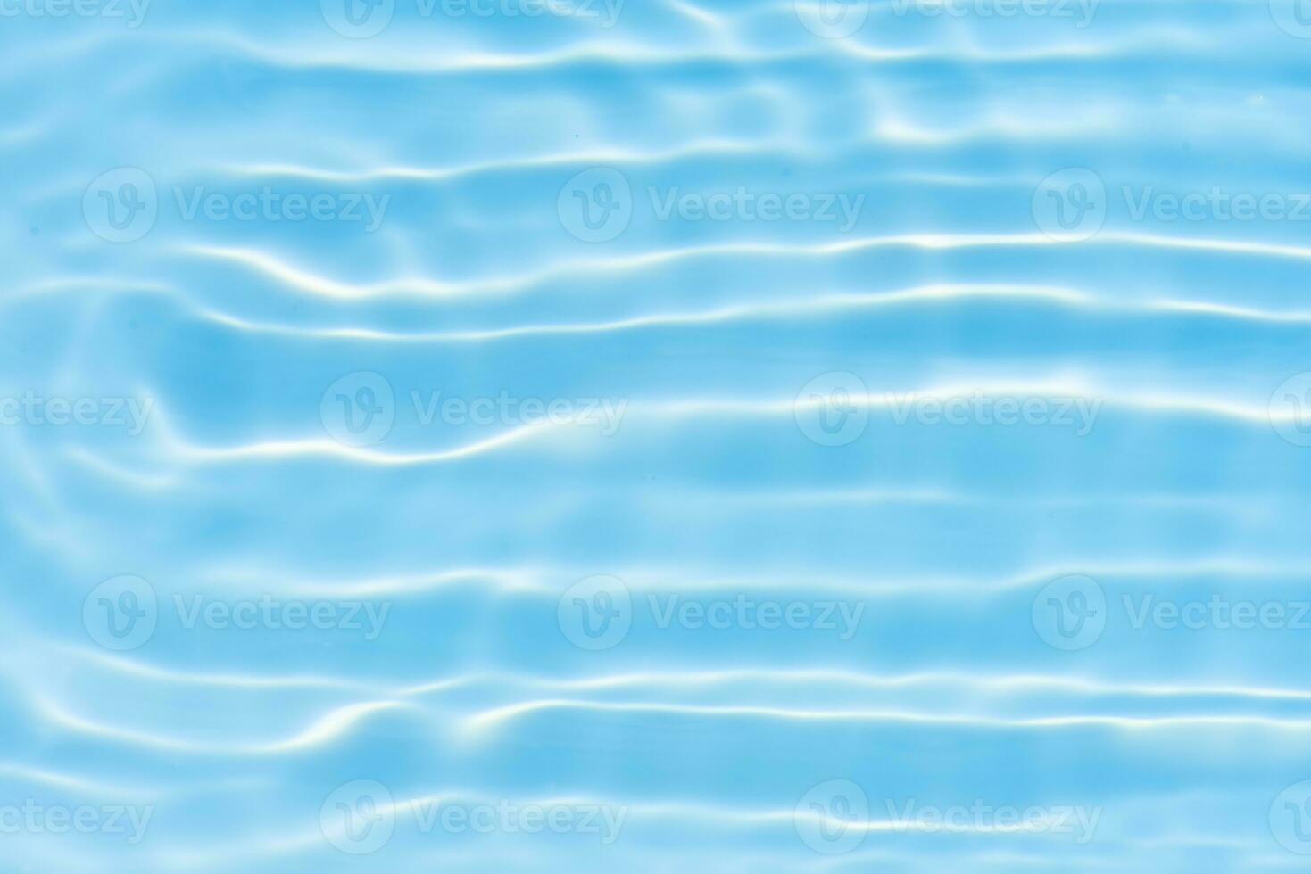 Blue water with ripples on the surface. Defocus blurred transparent blue colored clear calm water surface texture with splashes and bubbles. Water waves with shining pattern texture background. photo