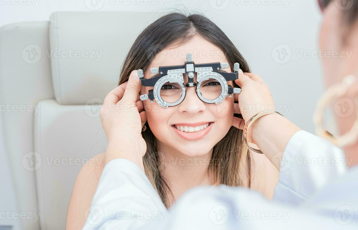 View of specialist checking vision of patient with trial frame in ophthalmology clinic. Vision check with optometrist trial frame on patient photo