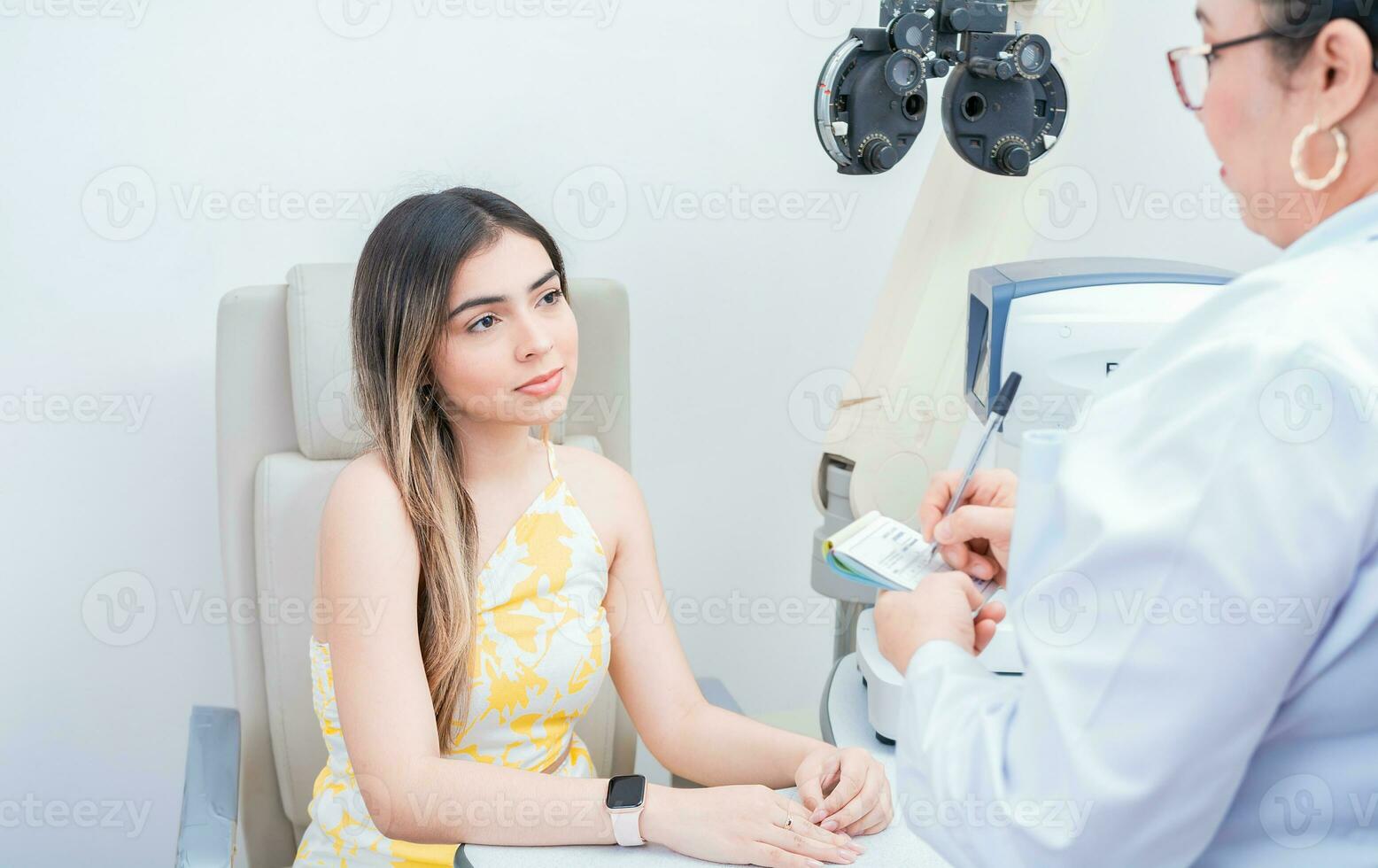 Female patient having consultation with optometrist in office. Optometrist with female patient taking notes in office. photo