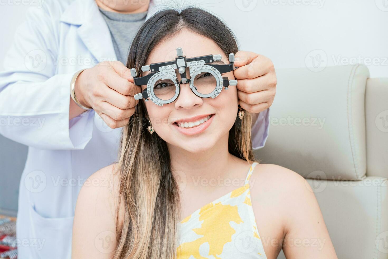 joven paciente con optometrista juicio marco. manos de optometrista examinando paciente con optometrista juicio marco foto