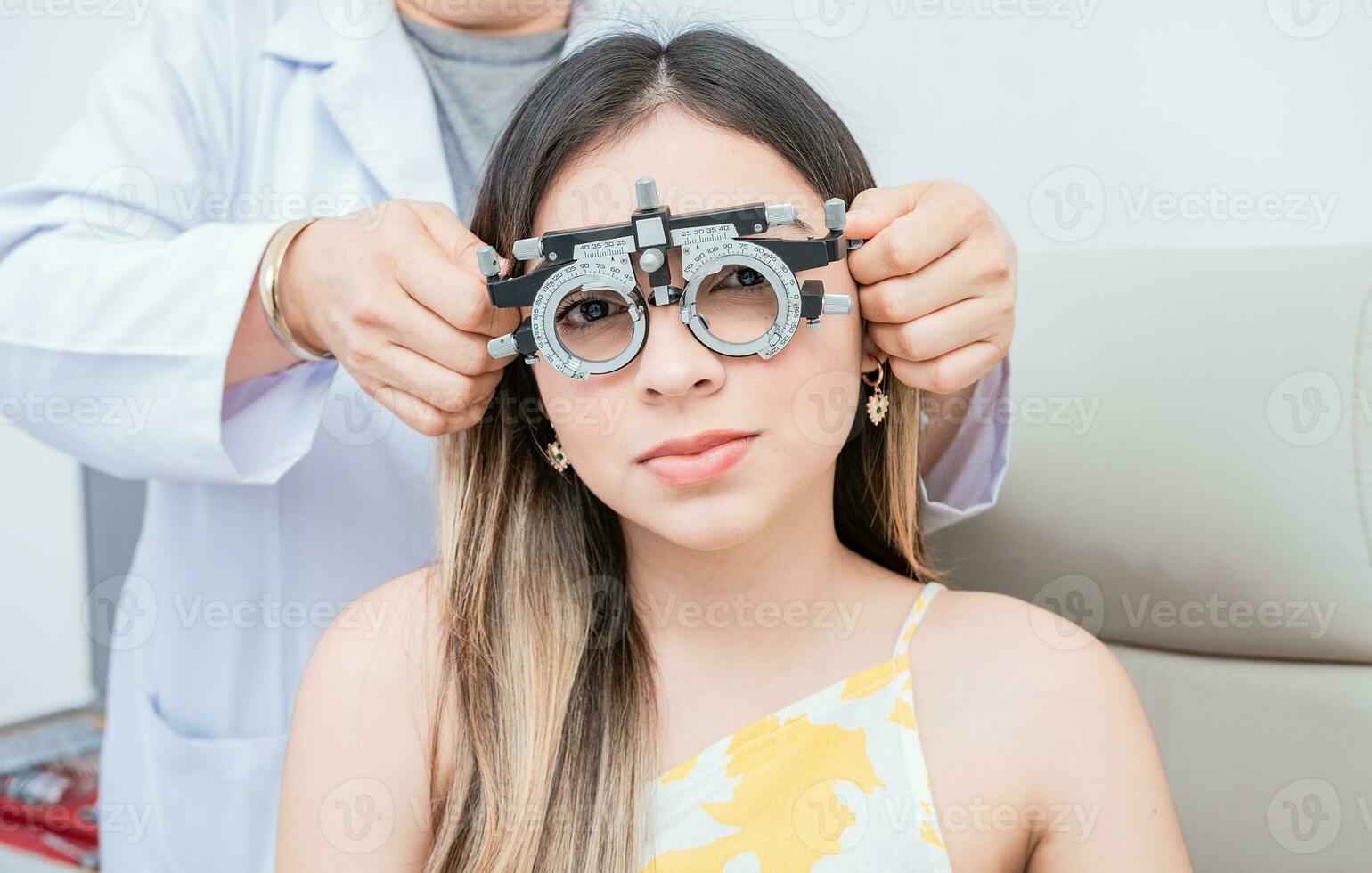 Hands of optometrist examining patient with optometrist trial frame. Young patient with optometrist trial frame photo