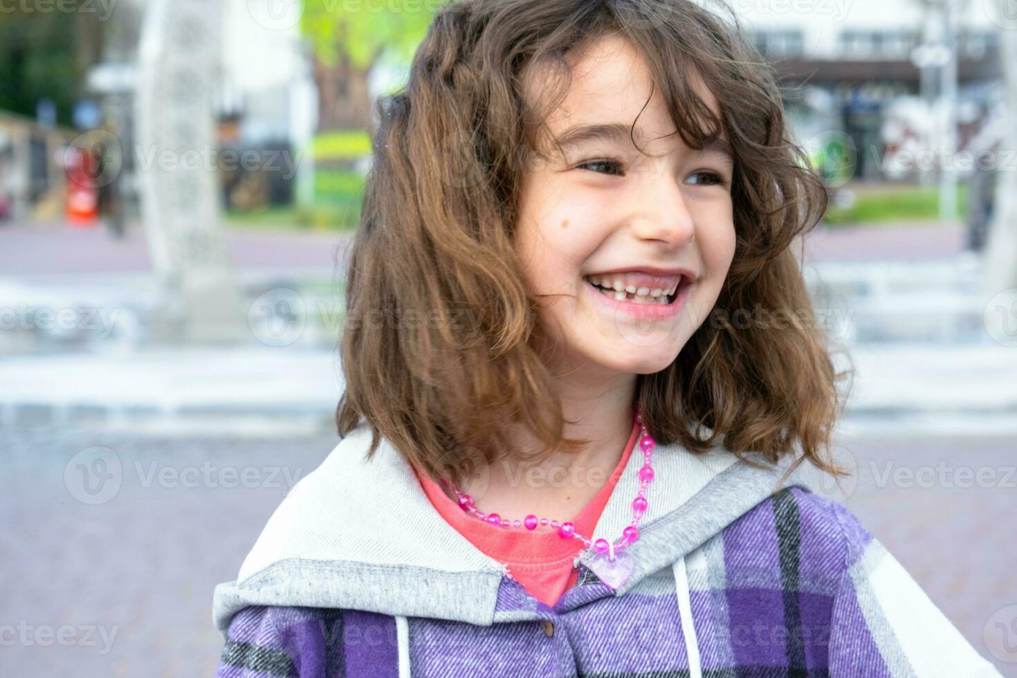 sin dientes contento sonrisa de un niña con un caído inferior Leche diente de cerca. cambiando dientes a molares en infancia foto